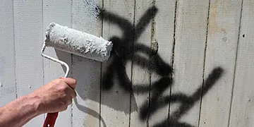 Farbrolle überstreicht Graffiti