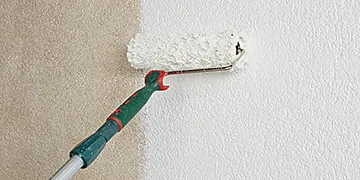 Farbrolle streicht Wand