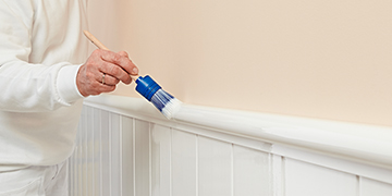 Maler streicht mit Pinsel