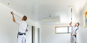 Zwei Maler streichen einen Raum